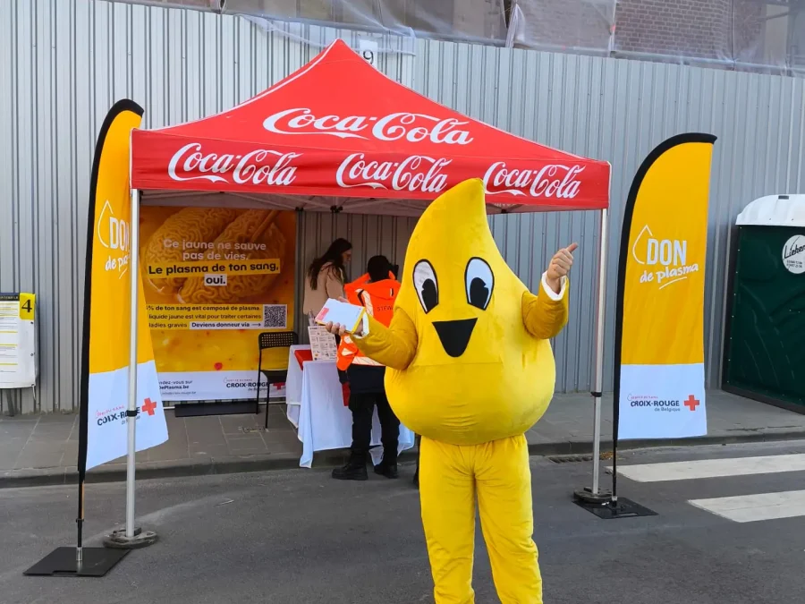 Mascotte Plasma devant un stand de don de sang de la Croix-Rouge